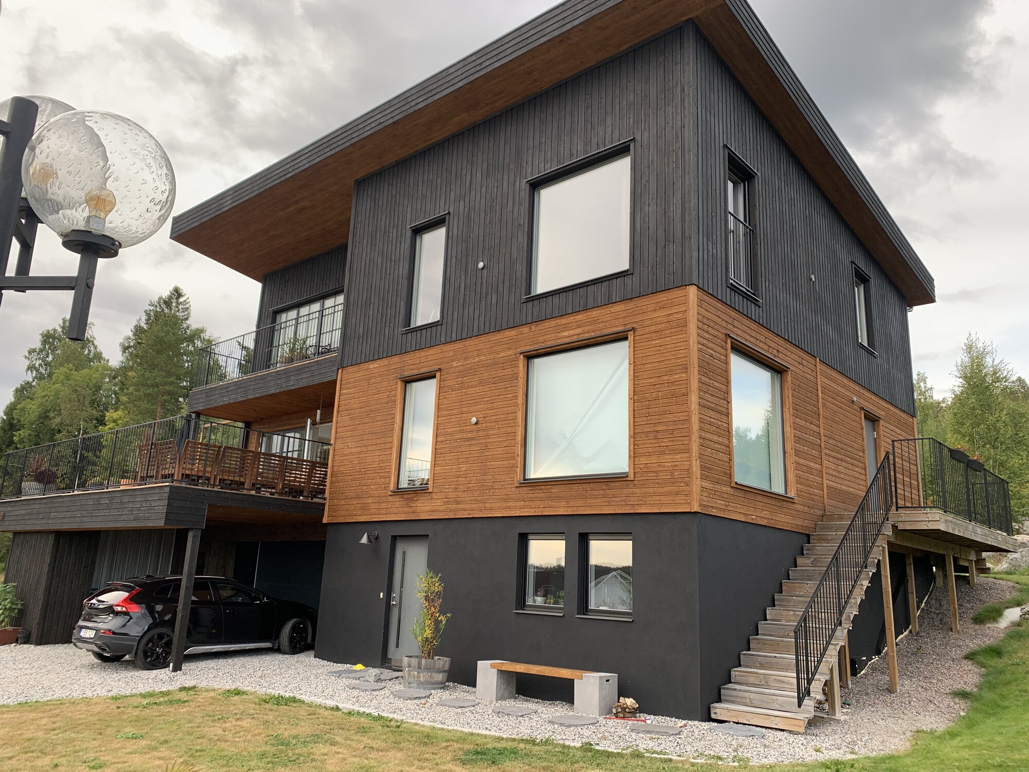 Nybyggd villa med svart träpanel och varm träfasad